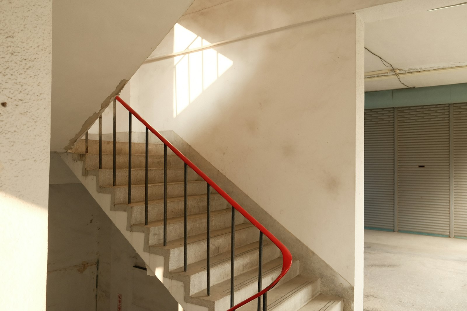Escadas de um prédio com corrimão vermelho